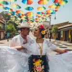 Bride and groom in traditional formal Mexican wedding attire, showcasing elegant dresses and suits
