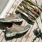 Quick dry fishing shoes sitting on a boat deck next to tackle gear.