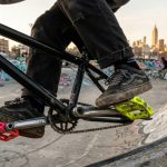 Rider performing a trick on BMX pedals at a New York skatepark.